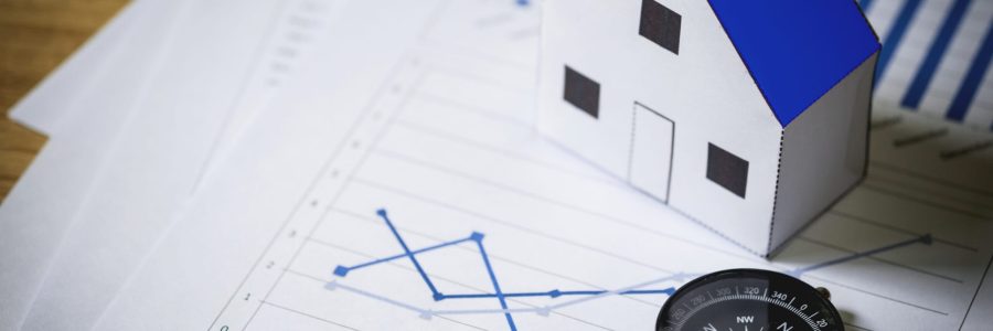 House model and compass on plan background, Real estate concept.